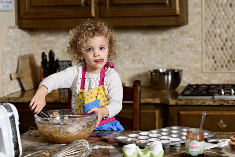 frisco family photographer 3 year old bakes with mom in kitchen