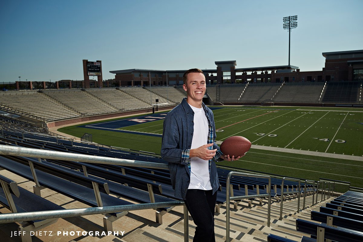 senior portraits allen student with football in the stands of eagles stadium