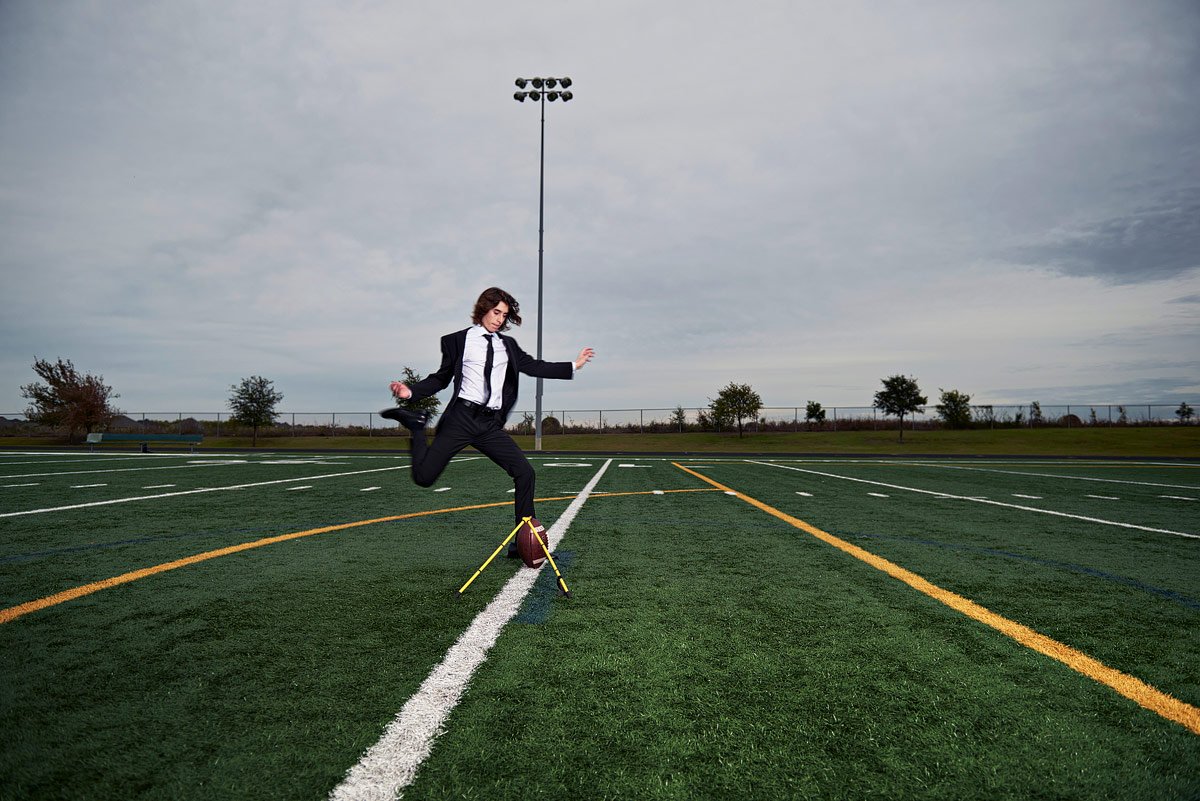 prosper football player kicking field goal in suit with senior photographer Jeff Dietz
