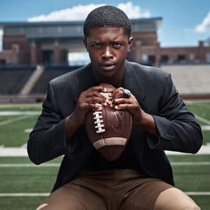 allen athlete crushes football in senior pictures in sports jacket