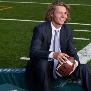 Dallas High School sports portraits of football player from prosper on field in suit