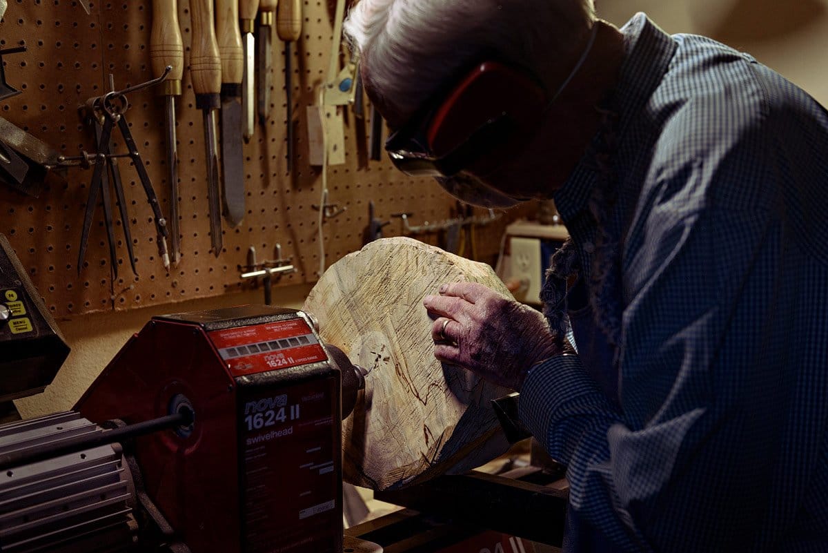 world war 2 veteran in mckinney texas photographed working on a block of wood in woodshop