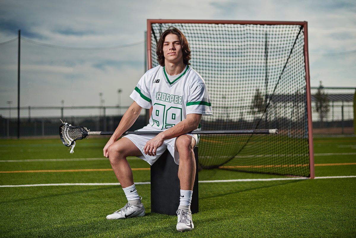 portriat of prosper lacrosse player sitting by the goal #99 with stick