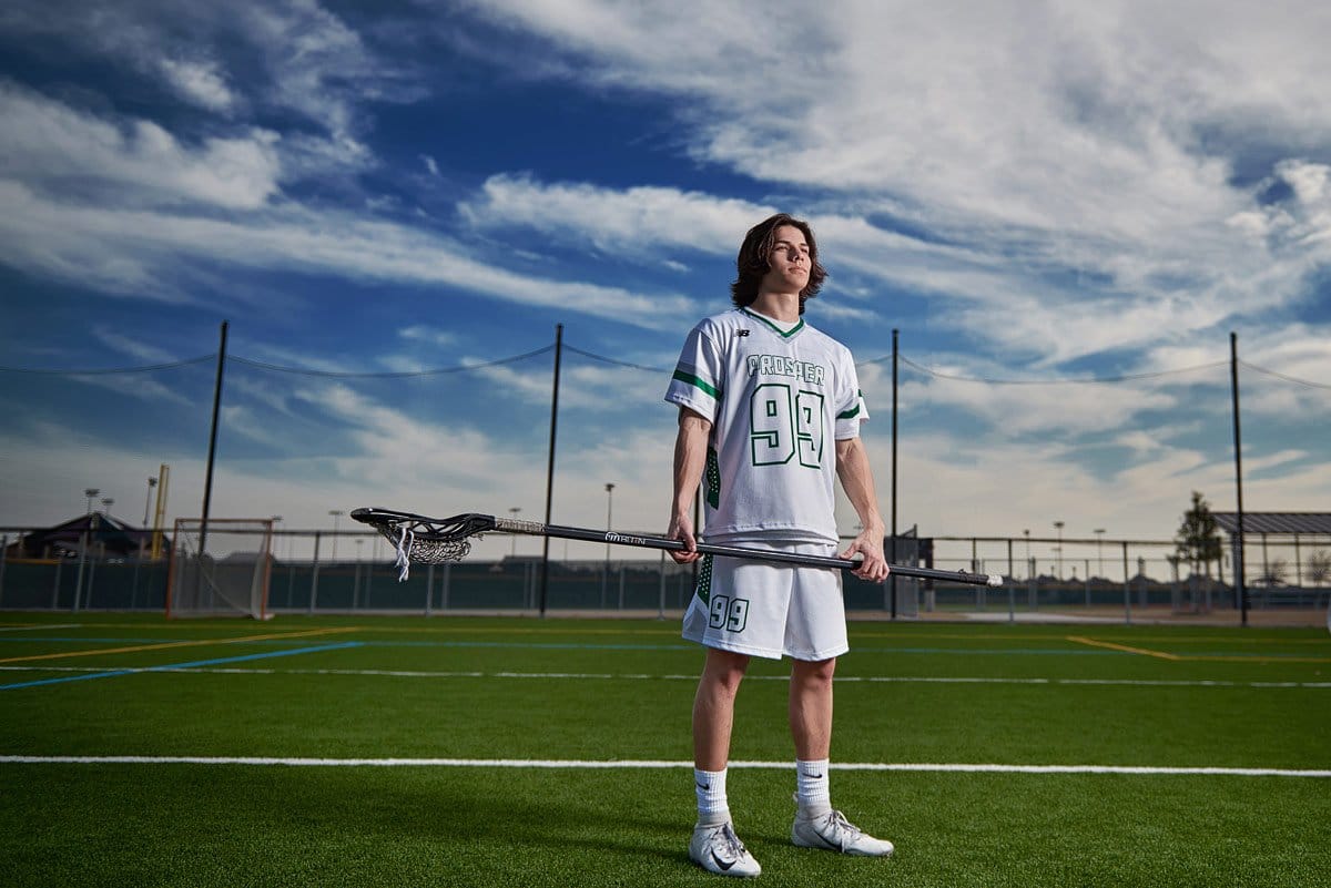 prosper lacrosse player stands with his defensive stick in jersey at frontier park