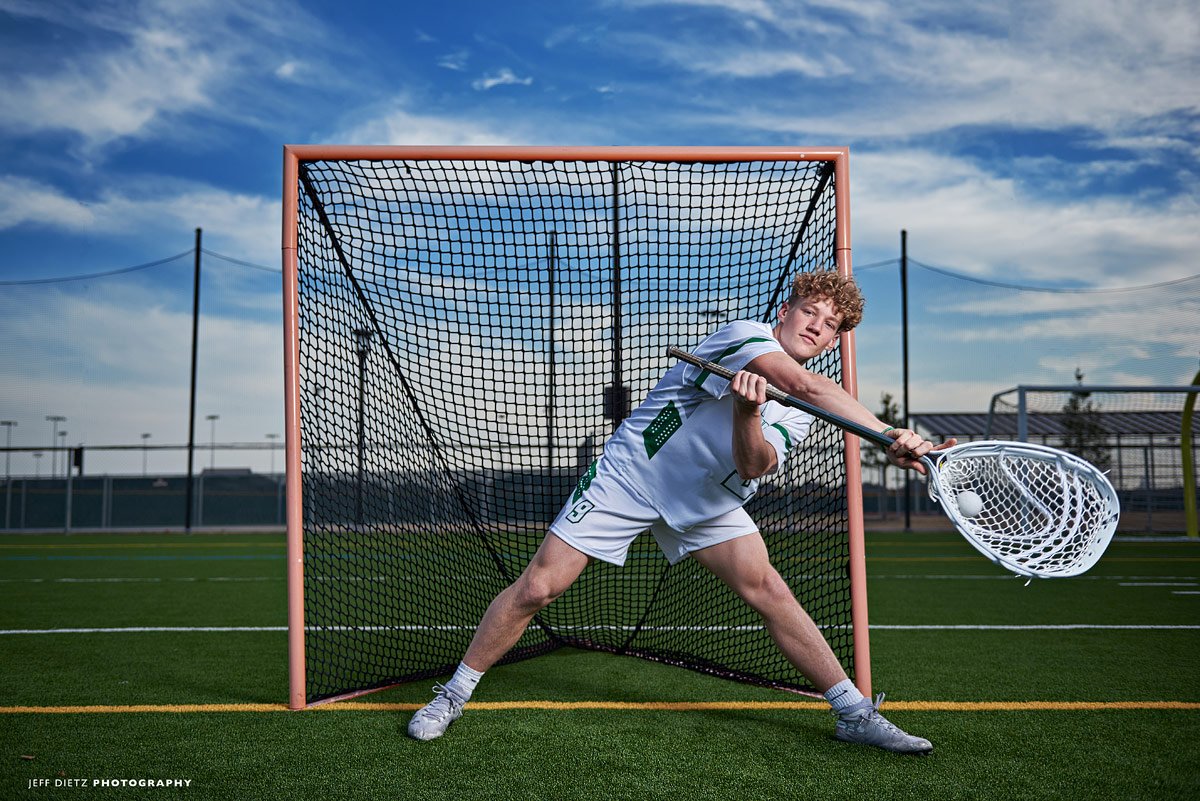 prosper lacrosse goalie blocks a shot in senior portraits at high school