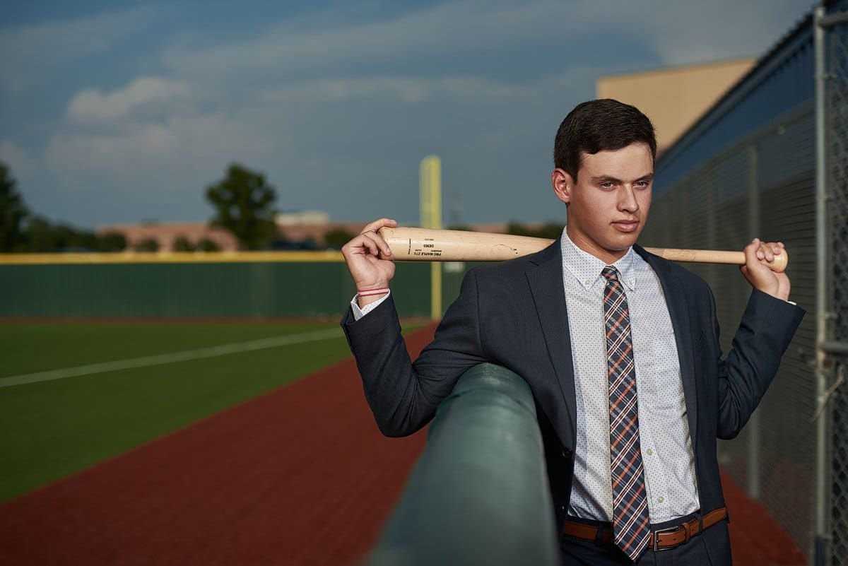 mckinney north senior baseball player poses with his bat behind his shoulders for his senior pictures