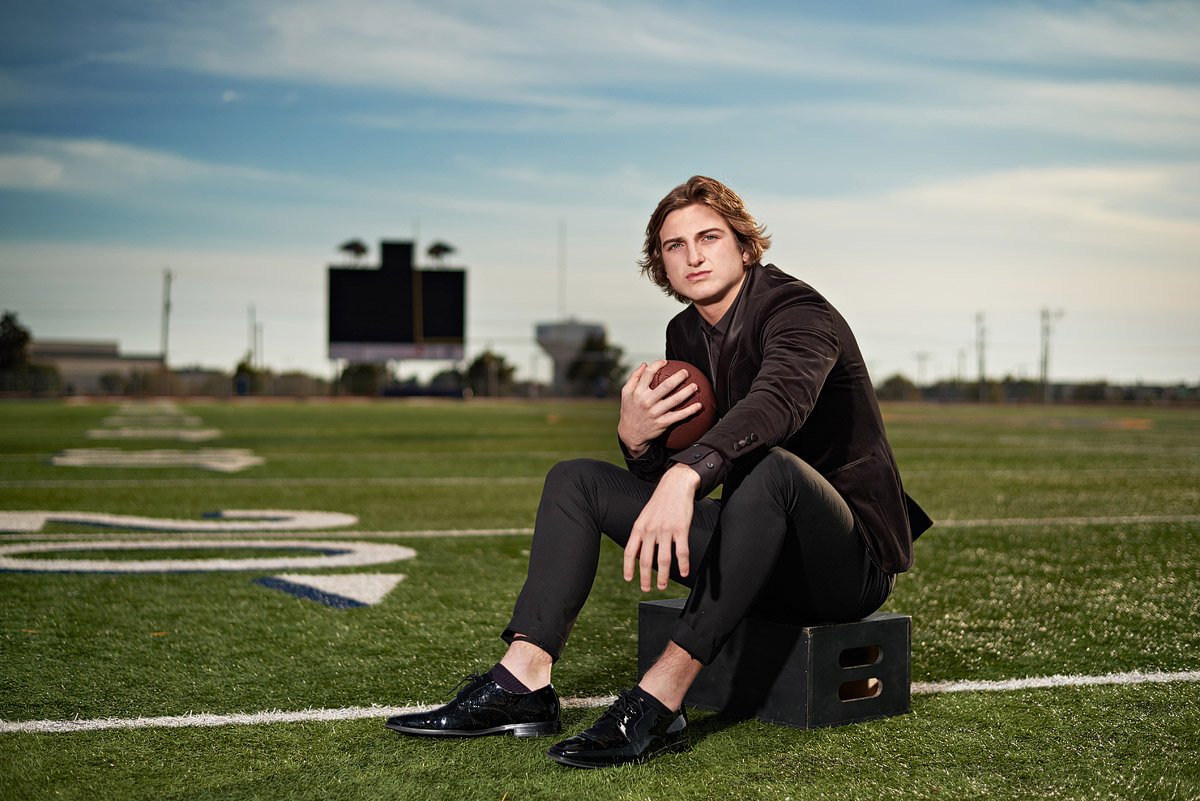 Prestonwood Christian senior portraits on the field with wide receiver in black suit