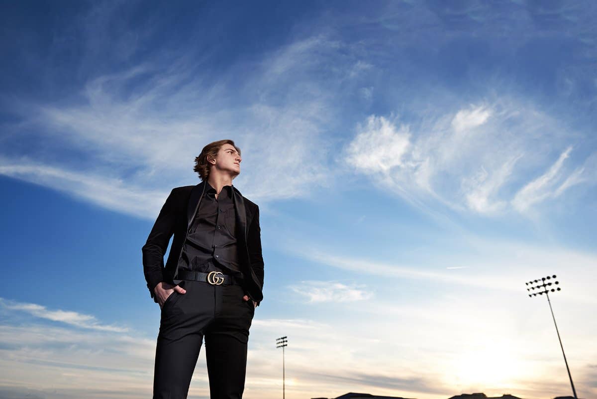 Prestonwood Christian Senior Pictures in Plano with black suit and blue sky