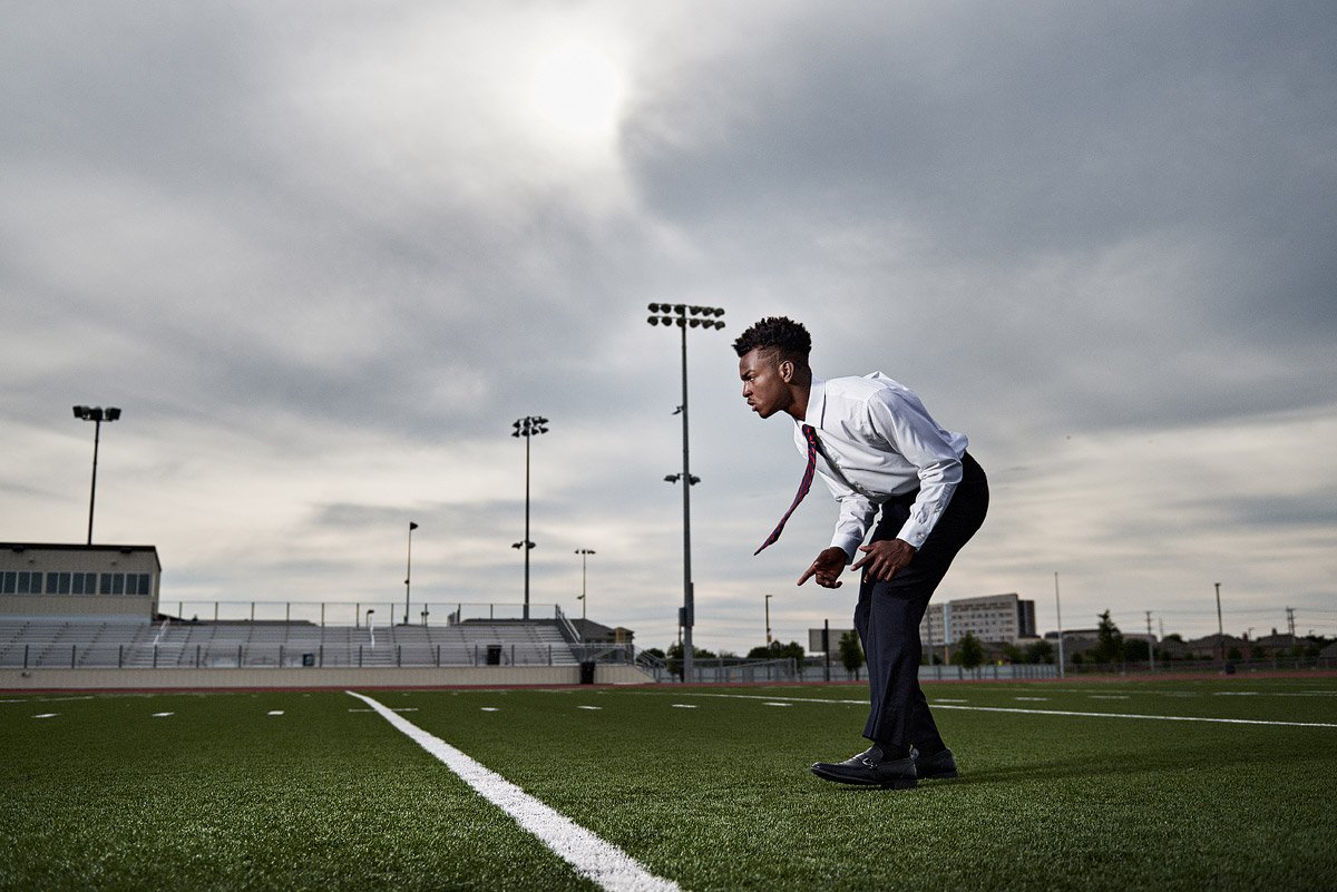 frisco senior portraits of wide receiver in a tie on the football field