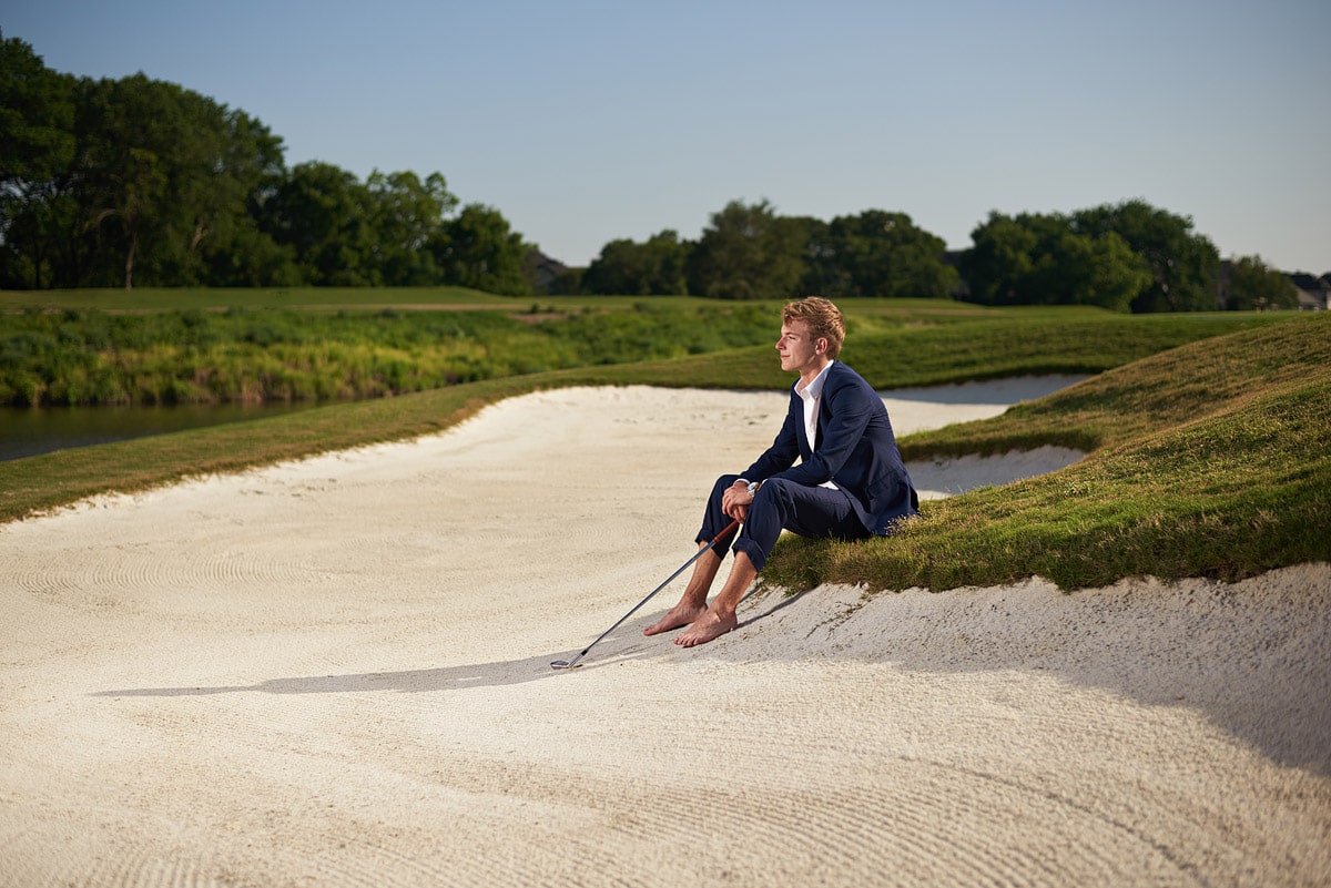 senior sitting in the sand trap at southlake country club