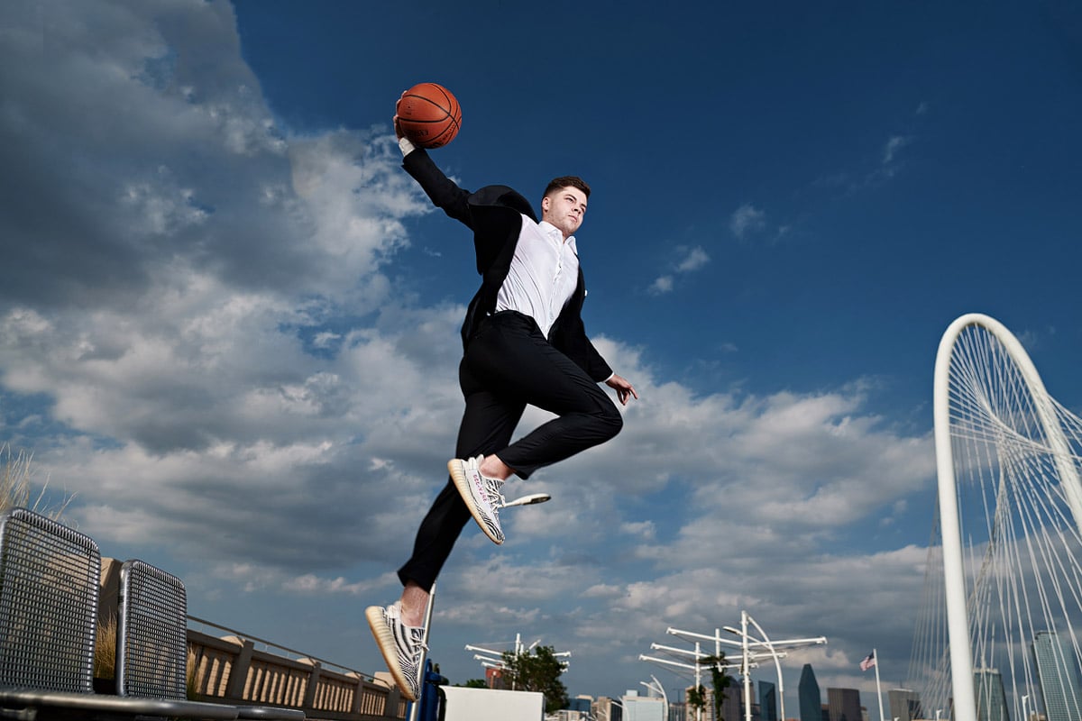 Bishop Lynch Senior Portraits of basketball player dunking and flying in the air on dallas bridge